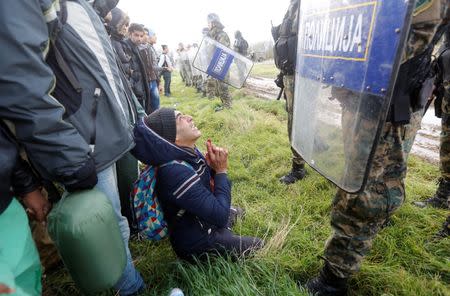 A migrant begs Macedonian police officers as he tries to cross the Greek-Macedonian border near the Greek village of Idomeni November 26, 2015. REUTERS/Yannis Behrakis
