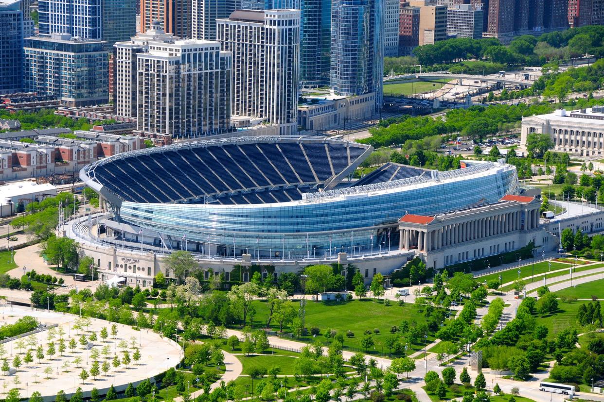 Chicago Bears, Soldier Field, Chicago, aerial of exterior and opened field on a sunny day during late spring, empty field, surrounded by greenery and city buildings to the left and top