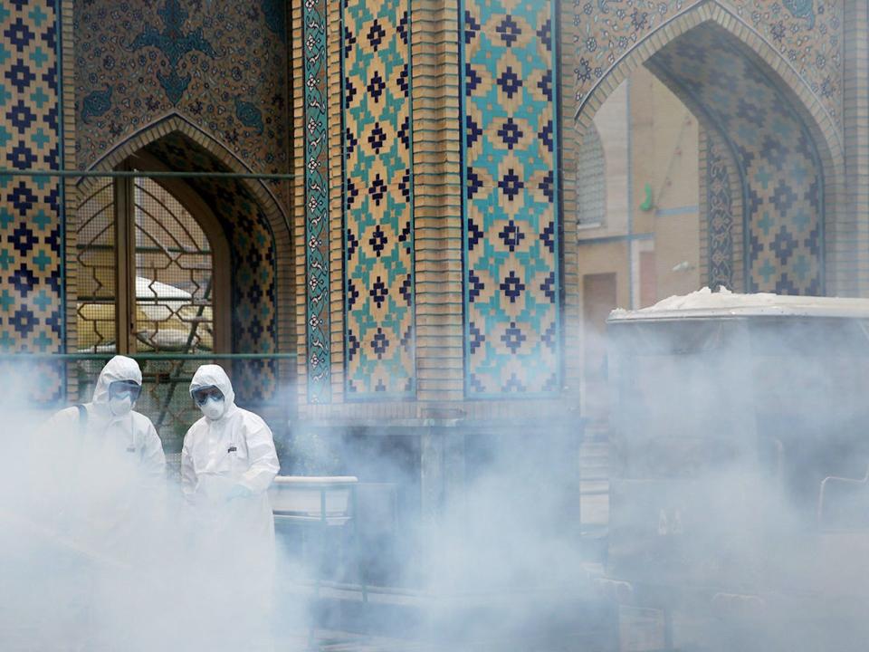 Members of a medical team spray disinfectant to sanitize outdoor place of Imam Reza's holy shrine, following the coronavirus outbreak, in Mashhad, Iran February 27, 2020. WANA (West Asia News Agency).JPG