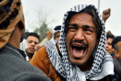 An Iraqi man mourns his brother during a funeral procession for anti-government demonstrators killed during protests in the central holy shrine city of Najaf