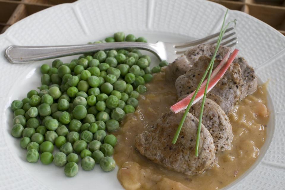 In this image taken on March 18, 2013, pork tenderloin medallions with rhubarb-orange sauce are shown served on a plate in Concord, N.H. (AP Photo/Matthew Mead)