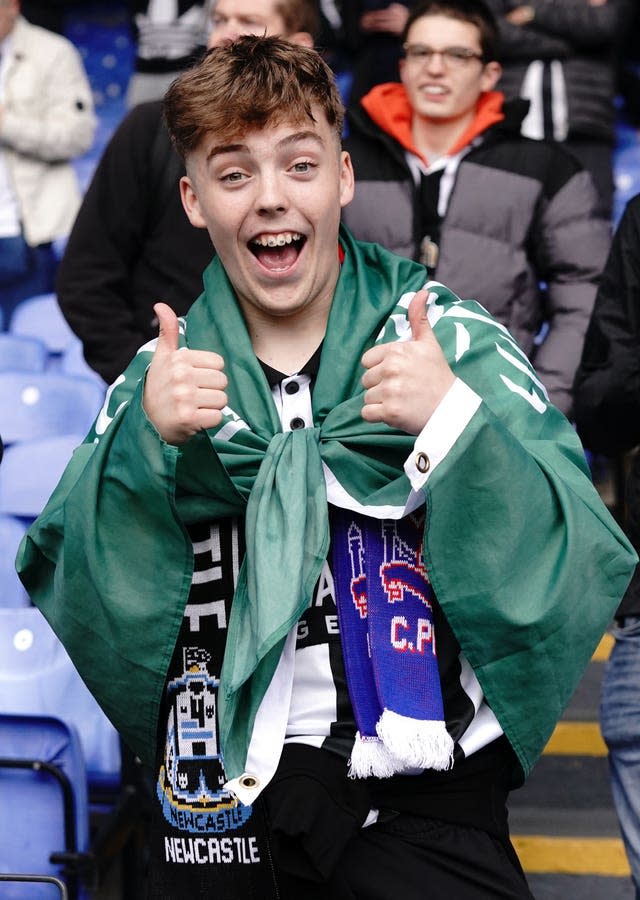 A Newcastle fan at Selhurst Park with the Saudi Arabian flag tied around his shoulders 