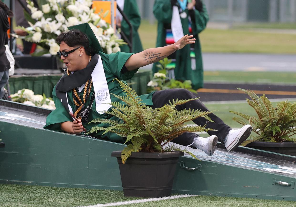 Gabriel Valenzuela loses his footing on the slippery ramp but is all smiles during Pacifica High School's commencement in Oxnard on Tuesday. Rainfall dampened the start of the ceremony but stopped about halfway through.