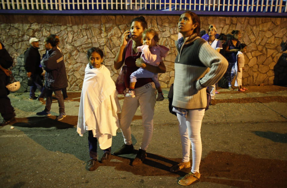 Residents stand outside their apartments in a street near the "Tower of David" skyscraper, which suffered an inclination after a powerful earthquake shook eastern Venezuela, causing buildings to be evacuated in the capital of Caracas, Venezuela, Tuesday, Aug. 21, 2018. The quake was felt as far away as Colombia's capital and in the Venezuelan capital office workers evacuated buildings and people fled homes. (AP Photo/Ariana Cubillos)