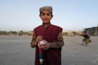 Khobiab, 7, from Kandahar province and who is learning how to play cricket poses for photograph at a playground in Kabul