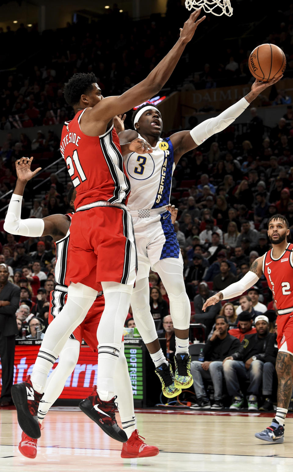 Indiana Pacers guard Aaron Holiday, right, drives to the basket on Portland Trail Blazers center Hassan Whiteside, left, during the first half of an NBA basketball game in Portland, Ore., Sunday, Jan. 26, 2020. (AP Photo/Steve Dykes)