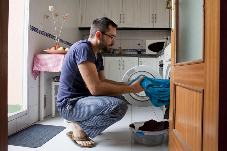 A man doing laundry in a kitchen