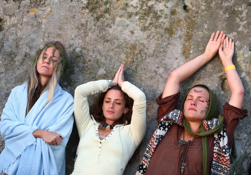 <p>People meditate as the sun rises on the Stonehenge monument on the summer solstice near Amesbury, Britain, June 21, 2017. (Photo: Neil Hall/Reuters) </p>