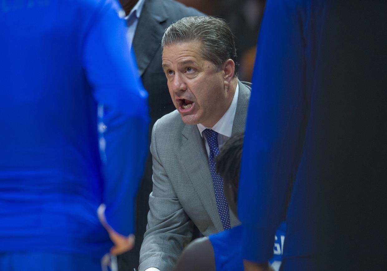 Kentucky Wildcats head coach John Calipari huddles with his players during a stoppage in play against the Tennessee Volunteers at Thompson-Boling Arena.