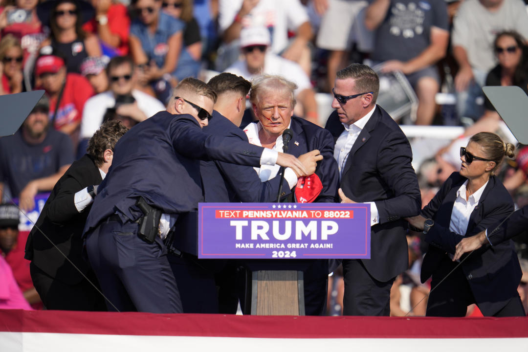 Republican presidential candidate former President Donald Trump is helped off the stage at a campaign event in Butler, Pa., on Saturday, July 13, 2024. (AP Photo/Gene J. Puskar)