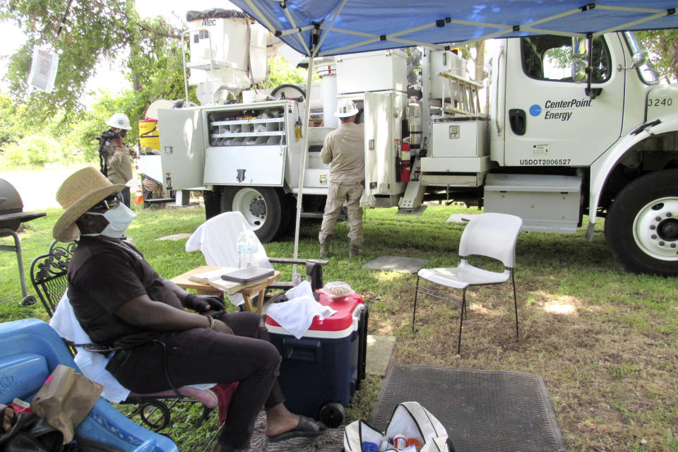 Houston resident Lloyd Nelms sits underneath a small tent Tuesday, May 26, 2020, and watched as utility workers set up electrical power at his newly constructed home. Nelms' family home had to be torn down after it was flooded during Hurricane Harvey in 2017. Nelms said he was unable to get help from a city program created to fix homes damaged during Harvey and had to endure hazardous living conditions for more than two years. He turned to the Texas General Land Office to rebuild his home. The city program has finished rebuilding less than 70 homes since beginning in January 2019. (AP Photo/Juan Lozano)