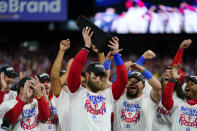 Philadelphia Phillies designated hitter Bryce Harper celebrates with the trophy after winning the baseball NL Championship Series in Game 5 against the San Diego Padres on Sunday, Oct. 23, 2022, in Philadelphia. (AP Photo/Matt Slocum)