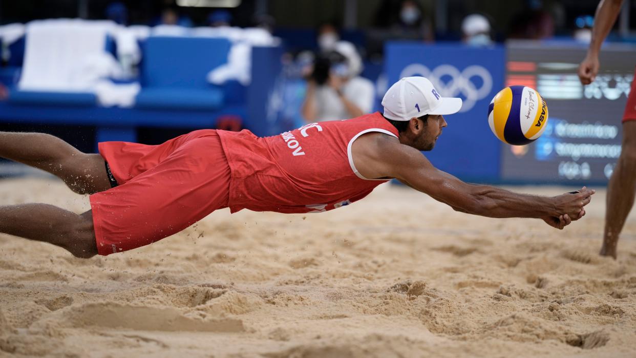 Viacheslav Krasilnikov, of the Russian Olympic Committee, dives for the ball during a men's beach volleyball match against Latvia at the 2020 Summer Olympics, Thursday, July 29, 2021, in Tokyo, Japan.