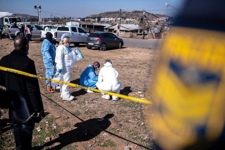 Agentes del Servicio de Policía de Sudáfrica (SAPS) refuerzan un perímetro alrededor de la escena del crimen en un bar en Soweto, Sudáfrica, el 10 de julio de 2022