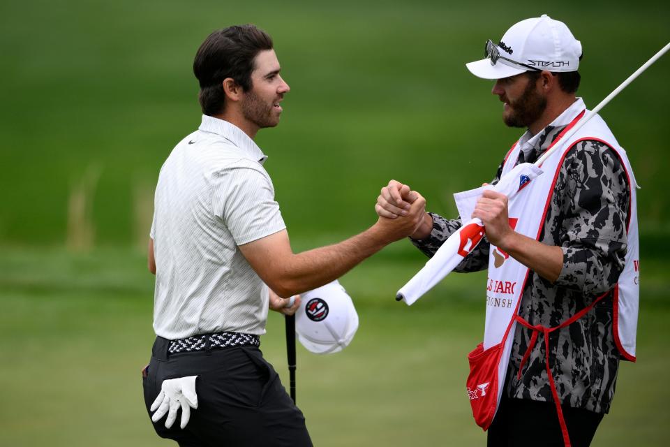 Matthew Wolff, left, shakes hands with his caddie, right, in May at TPC Potomac at Avenel Farm golf club in Potomac, Md. Wolff will be on Phil Mickelson's team for the LIV Golf Series tournament that started Thursday.