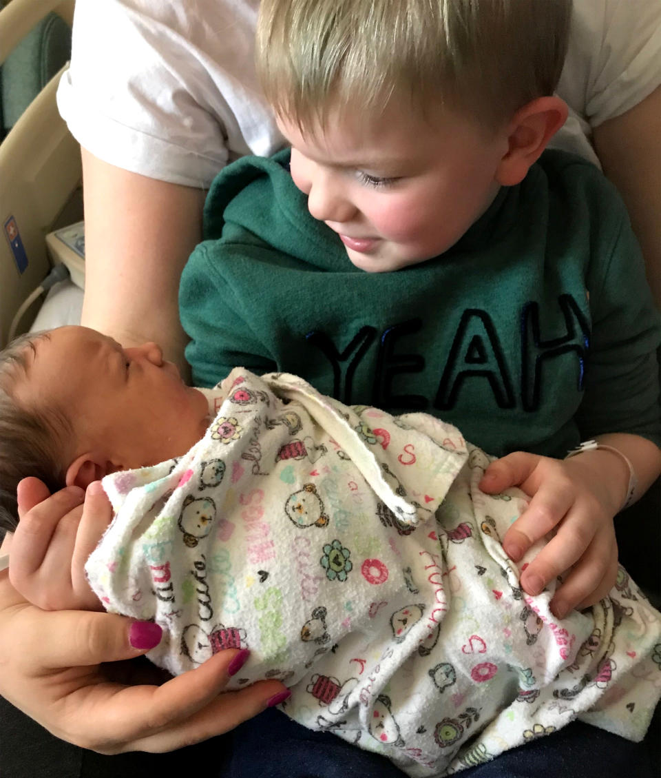 Atticus Svoboda holds his sister, Violet. 