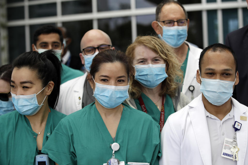 FILE - In this April 17, 2020 file photo Hospital personnel stand outside Providence St. John's Medical Center in Santa Monica, Calif. Three million surgical masks arrived in California last weekend as the first shipment in a major deal cut by California Gov. Gavin Newsom for 200 million masks per month to protect health care and other workers from the coronavirus. (AP Photo/Marcio Jose Sanchez,File)