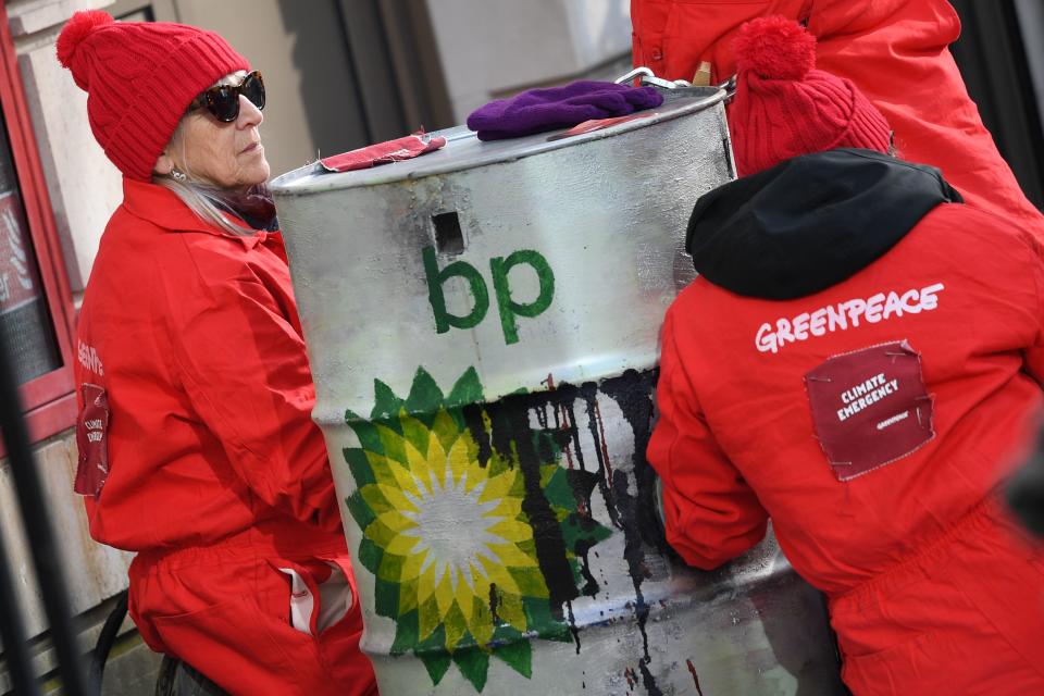 Greenpeace activists sit chained into oil barrels as they protest outside the headquarters of oil giant BP in London on February 5, 2020, on the day that the company's new  was set to take up his role. - Activists from Greenpeace on Wednesday blocked the headquarters of BP in London with solar panels and mock barrels of crude to mark the first day of the oil giant's new CEO, Bernard Looney. (Photo by DANIEL LEAL-OLIVAS / AFP) (Photo by DANIEL LEAL-OLIVAS/AFP via Getty Images)