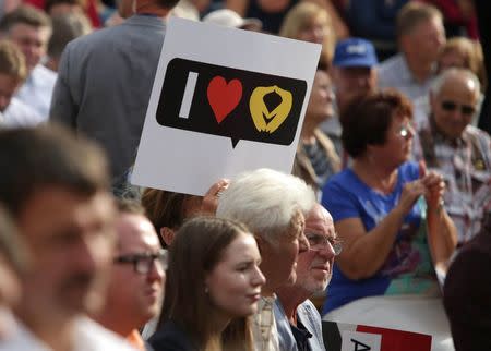 A woman holds placard as she waits for the election rally of the German Chancellor Angela Merkel, a top candidate of the Christian Democratic Union Party (CDU), ahead of the upcoming federal election in Annaberg-Buchholz, Germany August 17, 2017. REUTERS/Matthias Schumann