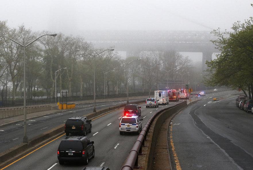 Part of the Williamsburg Bridge peeks through thick morning fog as police and fire department vehicles lead a procession along Franklin D. Roosevelt East River Drive with the unidentified remains of victims of the Sept. 11, 2001 attacks as they are returned to the World Trade Center site, Saturday, May 10, 2014, in New York. The remains were moved from the Office of the Chief Medical Examiner on Manhattan's East Side at dawn Saturday to an underground repository in the same building as the National September 11 Memorial Museum. (AP Photo/Julio Cortez)