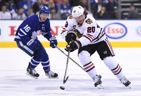 Mar 13, 2019; Toronto, Ontario, CAN; Chicago Black Hawks forward Brandon Saad (20) shoots the puck away from Toronto Maple Leafs forward Mitchell Marner (16) in the first period at Scotiabank Arena. Mandatory Credit: Dan Hamilton-USA TODAY Sports