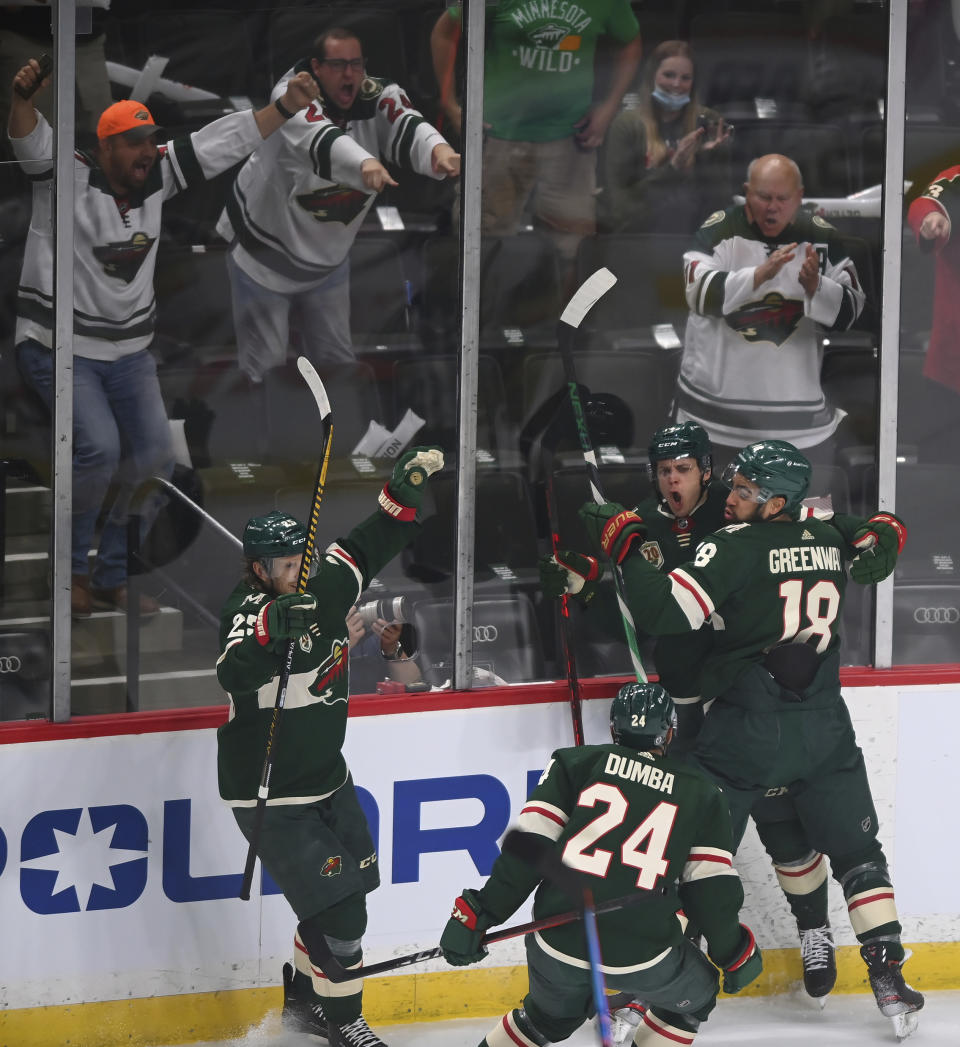 Minnesota Wild center Joel Eriksson Ek, second from right, celebrates his goal against the Vegas Golden Knights with left wing Jordan Greenway (18), defenseman Matt Dumba (24) and defenseman Jonas Brodin (25) during the first period in Game 3 of an NHL hockey first-round playoff series Thursday, May 20, 2021, in St. Paul, Minn. (Aaron Lavinsky/Star Tribune via AP)