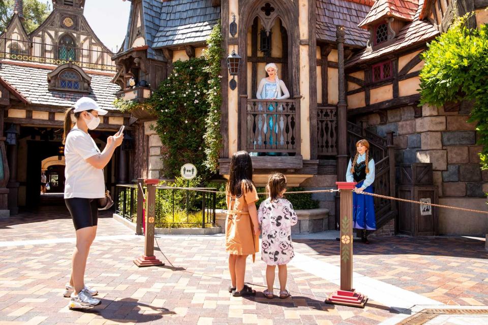 A family takes pictures and has socially distant interaction with Elsa and Anna characters at Disneyland Resort in Anaheim, CA.