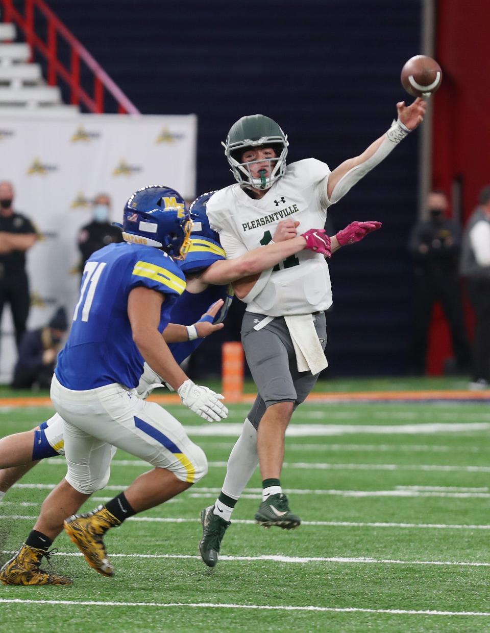 Pleasantville's Michael Lacapria (11) gets a pass off despite pressure from Maine-Endwell defenders during the Class B state football championship game in the Carrier Dome at Syracuse University Dec 4, 2021. Maine-Endwell won the game 21-12.