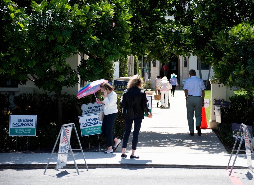 Volunteers and voters walk outside the Morton & Barbara Mandel Recreation Center on Tuesday.