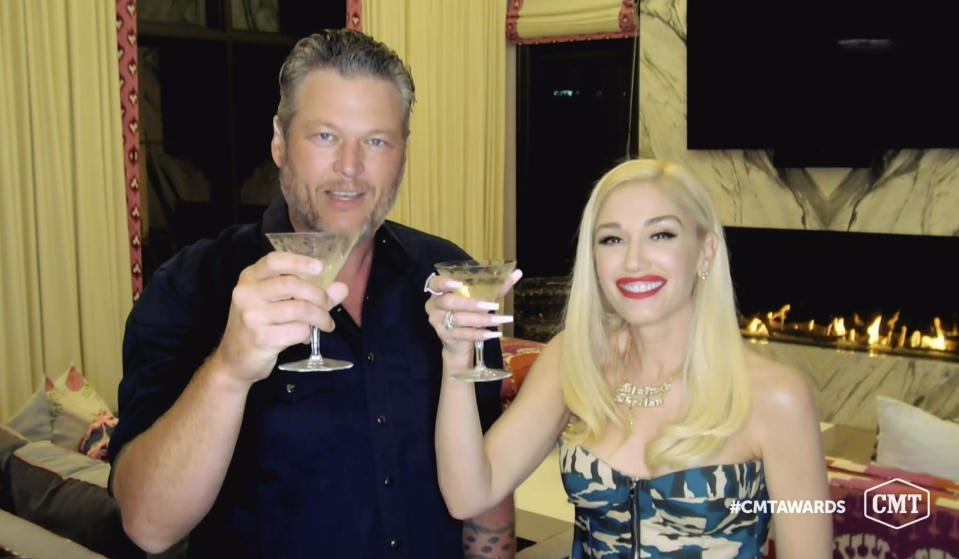In this video image provided by CMT, Blake Shelton, left, and Gwen Stefani toast as they accept the collaboration of the year award for “Nobody But You” during the Country Music Television awards airing on Wednesday, Oct. 21, 2020. (CMT via AP)