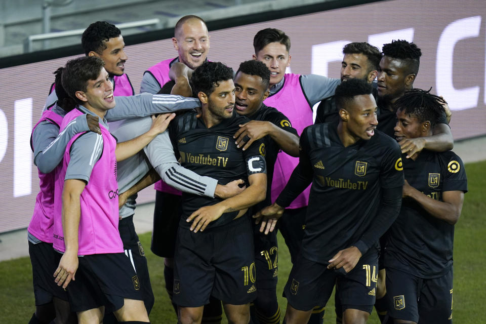 El mexicano Carlos Vela es felicitado por sus compañeros de Los Angeles FC, luego de anotar su segundo tanto ante el América en la semifinal de la Liga de Campeones de la CONCACAF, el sábado 19 de diciembre de 2020, en Orlando, Florida (AP Foto/John Raoux)