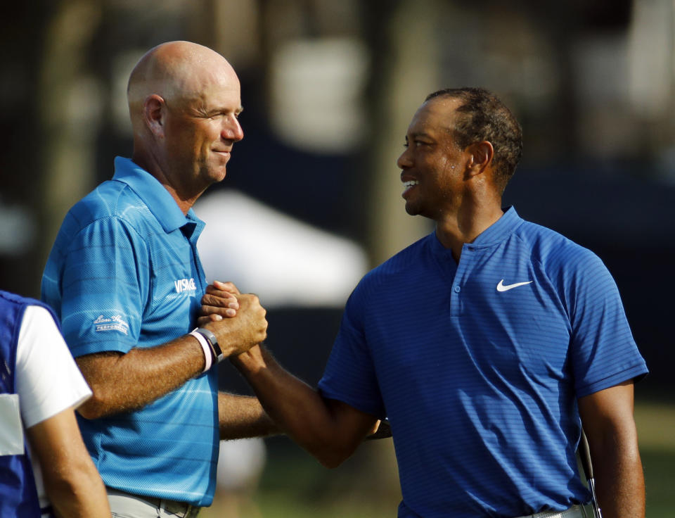 Stewart Cink, left, and Tiger Woods shake hands following the third round of the PGA Championship golf tournament at Bellerive Country Club, Saturday, Aug. 11, 2018, in St. Louis. (AP Photo/Charlie Riedel)
