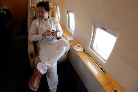 Imran Khan, chairman of the Pakistan Tehreek-e-Insaf (PTI), political party, holds his tasbih, while having tea on a plane on his way to a campaign rally ahead of general elections in Sialkot, Pakistan July 12, 2018. Picture taken July 12, 2018. REUTERS/Stringer