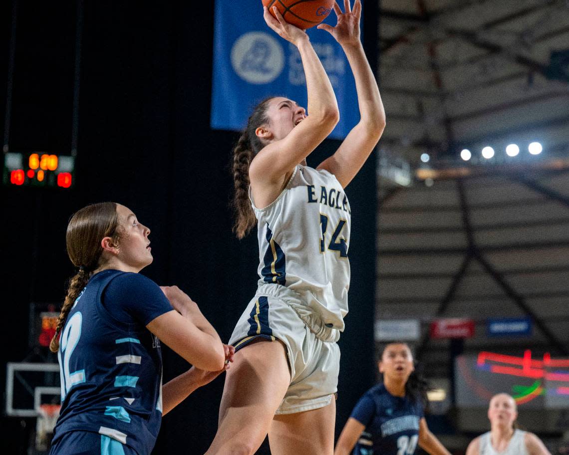 Arlington guard Jenna Villa (34) attempts a shot Meadowdale forward Mia Brockmeyer (12) defends during the second quarter of a Class 3A quarterfinal game on Thursday, March 2, 2023, in Tacoma, Wash.