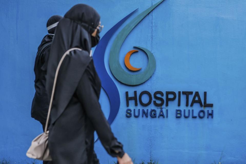 Doctors clad in black are seen outside the Sungai Buloh Hospital during a strike July 26, 2021. — Picture by Hari Anggara