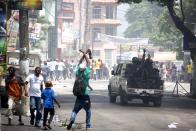 <p>Police officers patrol the street while people put fire in cars during a protest over the cost of fuel in Port-au-Prince, Haiti, Saturday, July 7, 2018. (Photo: Dieu Nalio Chery/AP) </p>