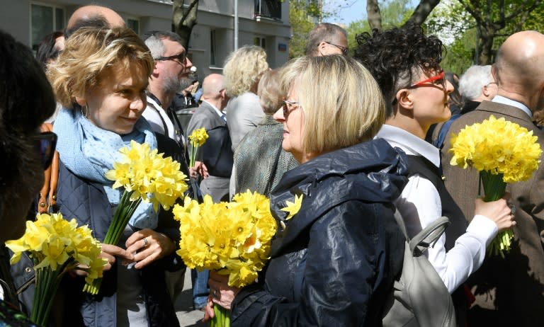 People in Warsaw hold daffodils, a reference to uprising commander Marek Edelman who would receive a bouquet of the flowers from an anonymous sender on the April 19 anniversary every year until his death in 2009