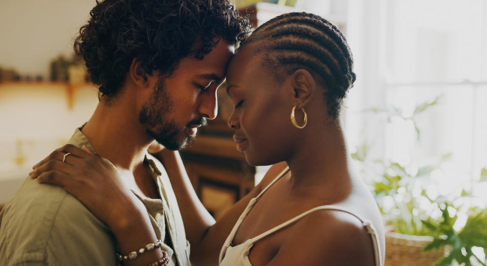 Two people embracing and touching foreheads affectionately