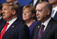 From left, U.S. President Donald Trump, German Chancellor Angela Merkel and Turkish President Recep Tayyip Erdogan pose during a group photo for a NATO leaders meeting at The Grove hotel and resort in Watford, Hertfordshire, England, Wednesday, Dec. 4, 2019. NATO Secretary-General Jens Stoltenberg rejected Wednesday French criticism that the military alliance is suffering from brain death, and insisted that the organization is adapting to modern challenges. (Peter Nicholls, Pool Photo via AP)