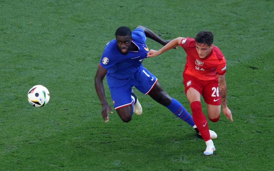 Dayot Upamecano  and Kacper Urbanski challenge each other for the ball