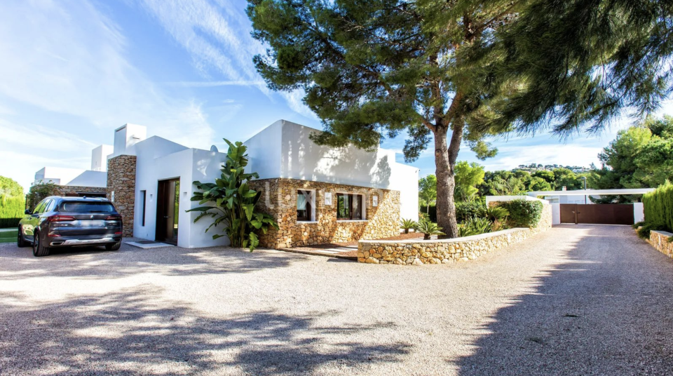 Entrada y vista general de la fachada de la vivienda, de líneas rectas y sencillas, con muros que mezclan la piedra y el color blanco. Foto: cortesía de luxinmo.com.