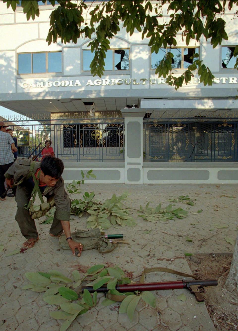 A Cambodian government soldier inspects a grenade launcher used  during a battle in Phnom Penh on June 17, 1997, after Funcinpec and Cambodian People's Party troops traded gunfire and rockets in fighting that left at least one soldier dead. One rocket struck the U.S. Embassy.