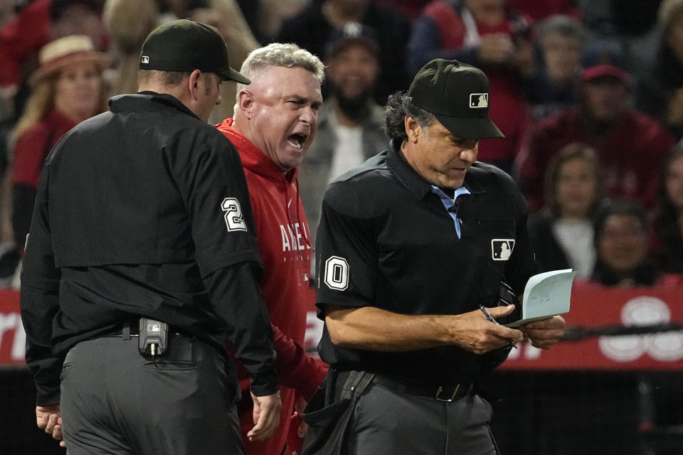 Los Angeles Angels manger Phil Nevin, center, argues with home plate umpire Phil Cuzzi, right, as third base umpire Dan Bellino stands by after Shohei Ohtani struck out looking during the fifth inning of a baseball game against the Seattle Mariners Saturday, June 10, 2023, in Anaheim, Calif. (AP Photo/Mark J. Terrill)