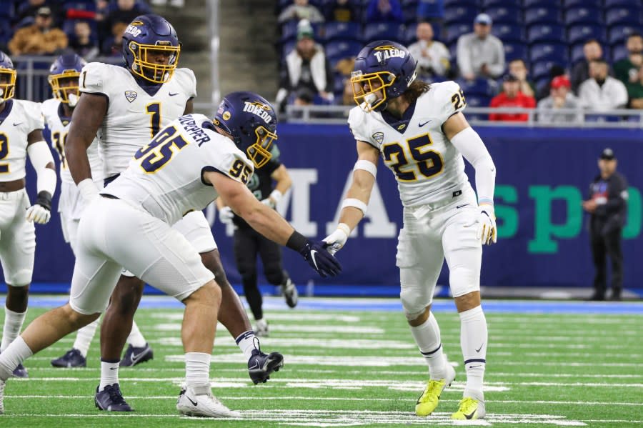 DETROIT, MI – DECEMBER 03: Toledo Rockets defensive tackle Judge Culpepper (95) and Toledo Rockets safety Maxen Hook (25) celebrate a defensive play during the Mid-American Conference college football championship game between the Toledo Rockets and the Ohio Bobcats on December 3, 2022 at Ford Field in Detroit, Michigan. (Photo by Scott W. Grau/Icon Sportswire via Getty Images)