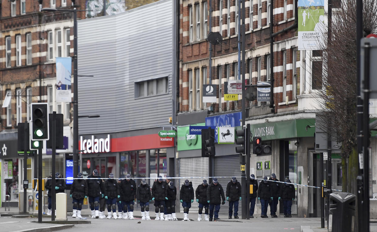 Police officers work at the scene of Sunday's terror stabbing attack in the Streatham area of south London Monday Feb. 3, 2020. Police in London say the man identified as 20-year-old Sudesh Amman was wearing a fake bomb and stabbed two people Sunday before being shot to death by police was recently released from prison, where he was serving for terrorism offenses. (AP Photo/Alberto Pezzali)