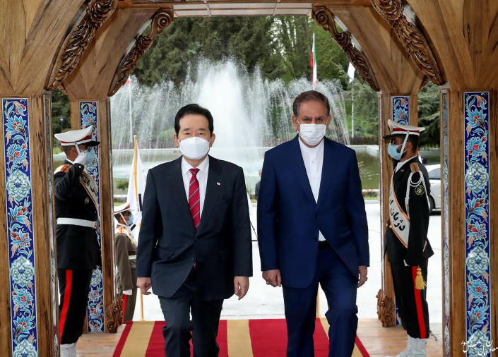 In this photo released by the official website of the office of the Iranian Senior Vice- President, Senior Vice-President Eshaq Jahangiri, right, and South Korea's Prime Minister Chung Sye-kyun walk during a welcoming ceremony for Sye-kyun in Tehran, Iran, Sunday, April 11, 2021. (Office of the Iranian Vice President via AP)