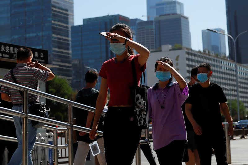 Personas usan mascarillas mientras se dirigen al trabajo durante la hora punta de la mañana en Pekín, China, el 15 de junio de 2020