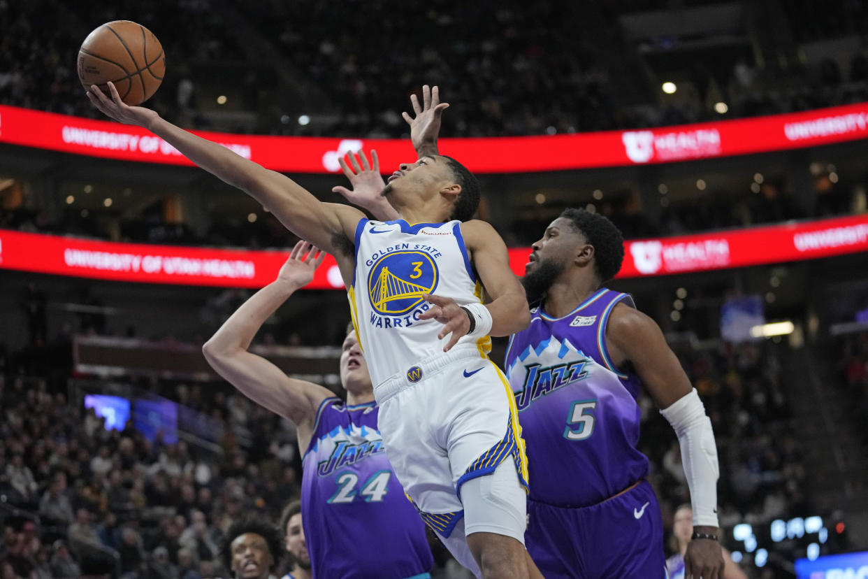 Golden State Warriors guard Jordan Poole (3) goes to the basket as Utah Jazz's Walker Kessler (24) and Malik Beasley (5) defend during the first half of an NBA basketball game Wednesday, Dec. 7, 2022, in Salt Lake City. (AP Photo/Rick Bowmer)