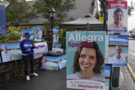 A volunteer stands outside a polling booth in Sydney, Australia, Monday, May 9, 2022. Early voting has begun in Australia's federal election with the opposition party hoping the first ballots will reflect its lead over the government in an opinion poll. (AP Photo/Mark Baker)