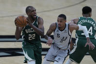 Milwaukee Bucks forward Khris Middleton (22) drives around San Antonio Spurs guard Dejounte Murray (5) during the first half of an NBA basketball game in San Antonio, Monday, May 10, 2021. (AP Photo/Eric Gay)